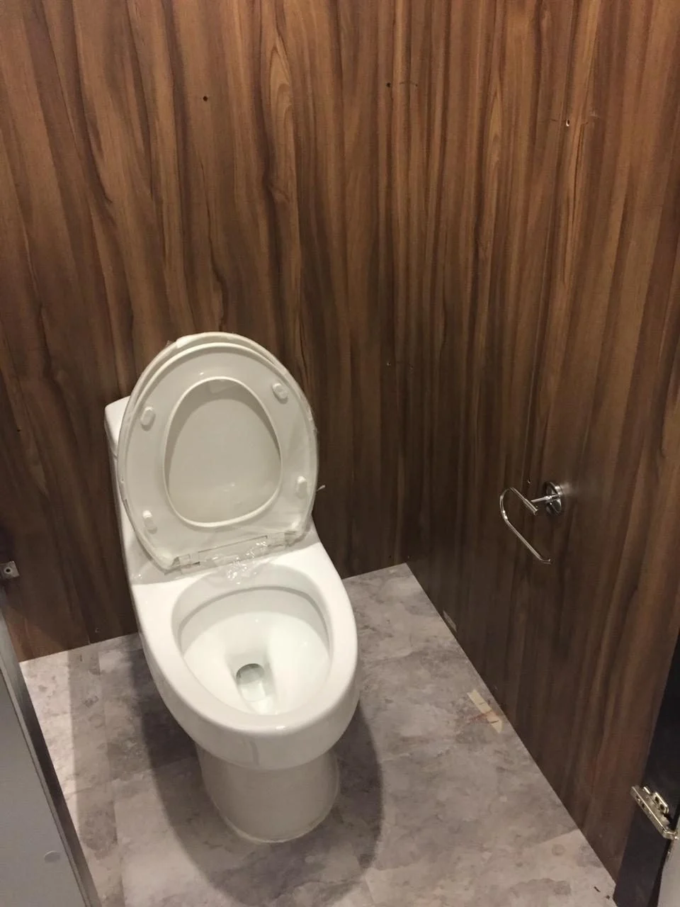 Inodoro blanco de porcelana dentro de un cubículo del baño remolque VIP con paredes de madera